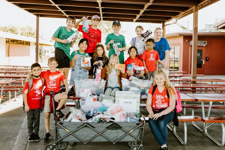 Students at Lee Elementary pose with the socks they collected in January to donate to people experiencing homelessness. Back