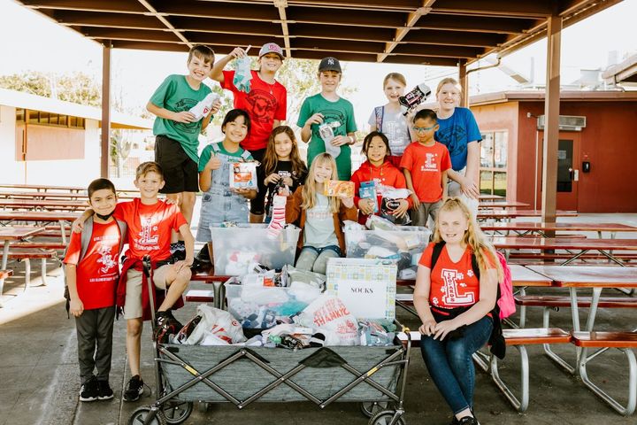 Students at Lee Elementary pose with the socks they collected in January to donate to people experiencing homelessness. Back