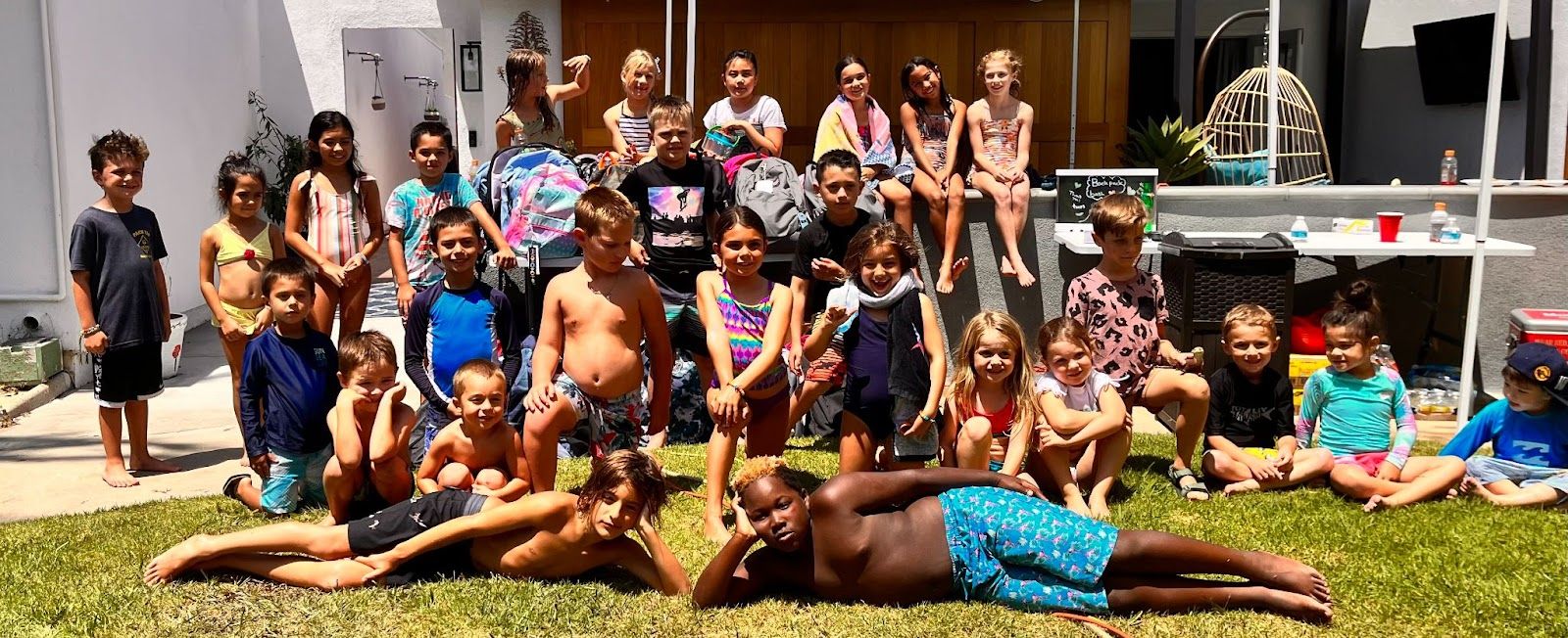 Students and guests at the Backpack Bash outside McGaugh teacher Lyndsey Gardner's home pose with the items they donated. Photo by Jeannette Andruss