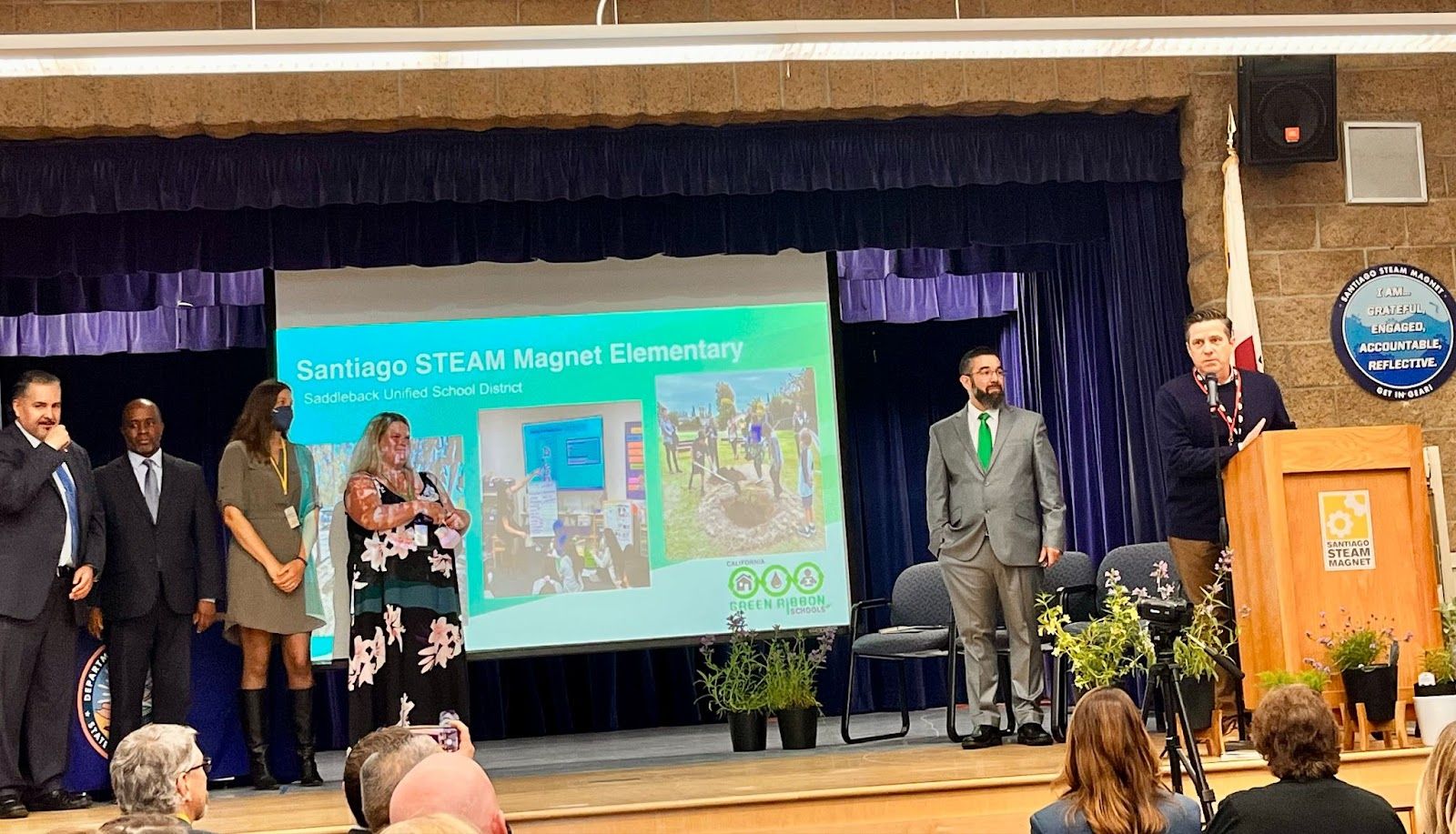 Santiago STEAM Magnet Principal Howard Johnston speaks at the California Department of Education Green Ribbon Schools awards ceremony held at the Lake Forest campus on May 25. Tony Thurmond, California Superintendent of Public Schools, second from left, also spoke at the event. Photo by Jeannette Andruss.