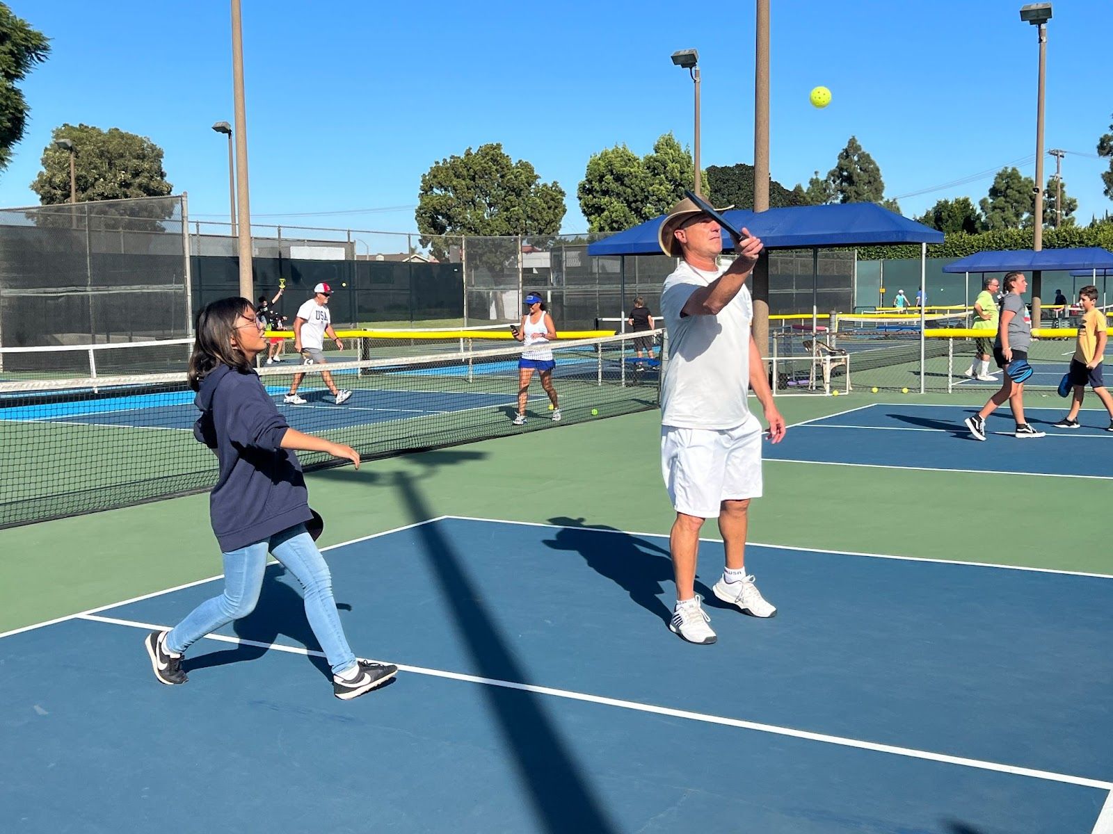 Seal Beach Pickleball Association President Mike Varipapa works with a student from the McAuliffe Pickleball Club on Oct. 19. Photo by Nichole Pichardo of Los Alamitos USD.