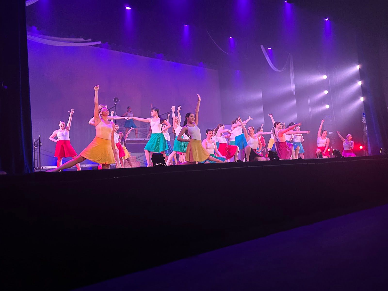 Dancers undo their plain costumes to reveal a rainbow of colored skirts. Photo by Bella Kim