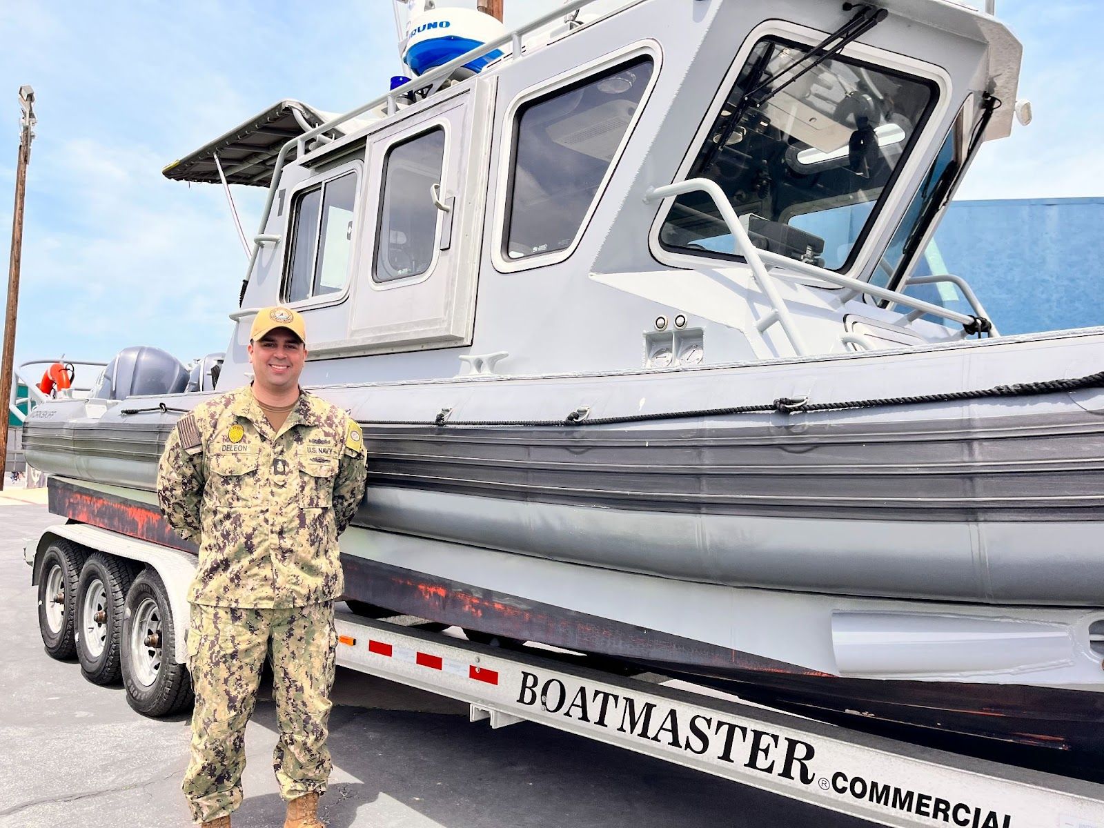 Armando Deleon, Senior Chief Master-at-Arms with the Navy, poses in front of a harbor patrol boat brought on the McGaugh campus during "Week of the Military Child." Photo by Jeannette Andruss
